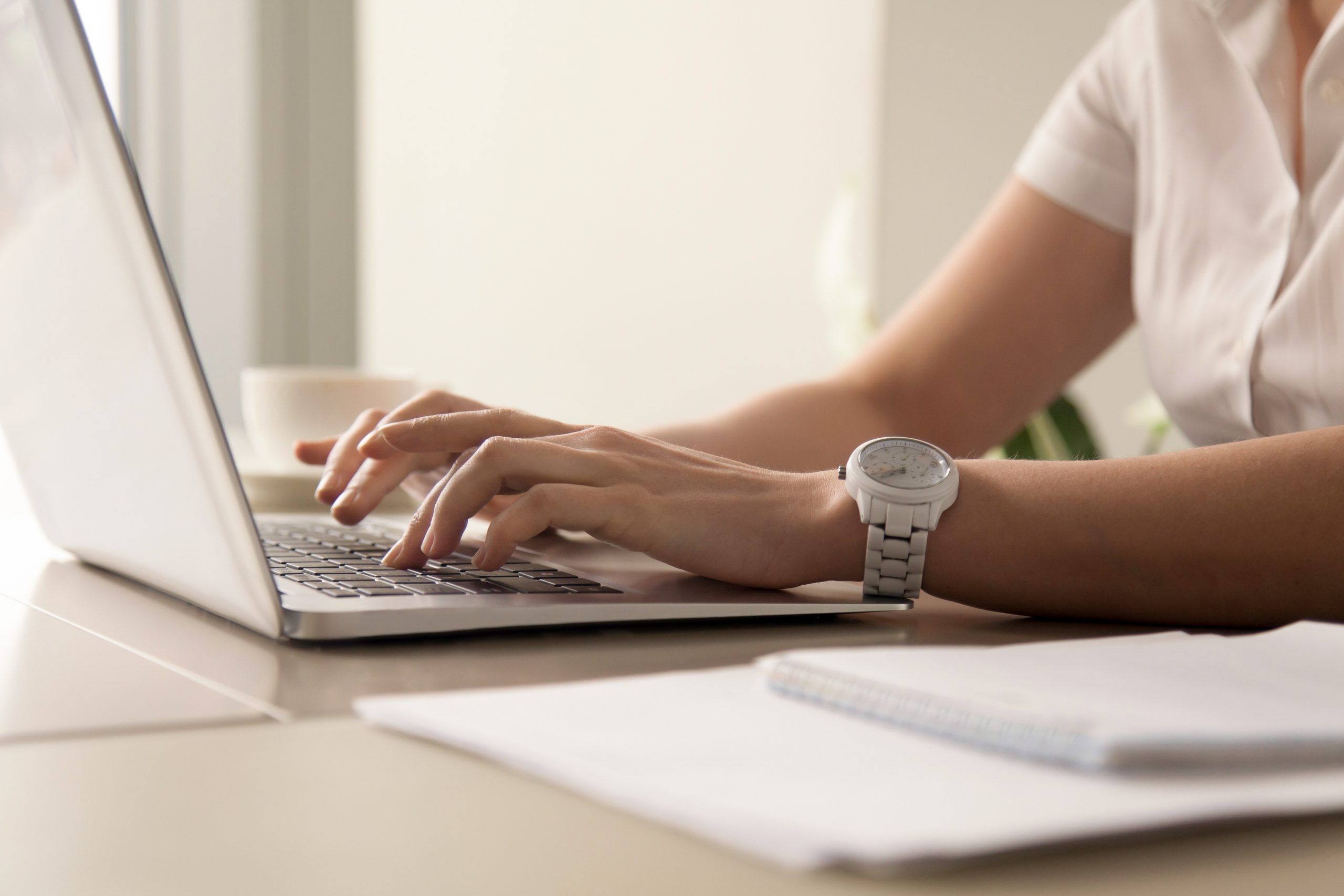 Glossar, hier eine Dame am Schreibtisch mit Notebook zu sehen