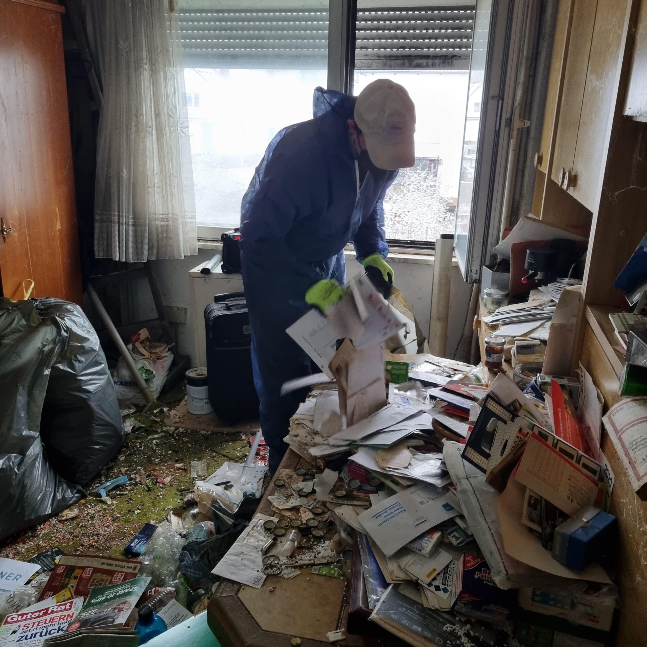 Messiehaushalt - FAIRwerter Berlin Messiehaushalt, hier ein Mitarbeiter in einem Zimmer voll Unrat zu sehen