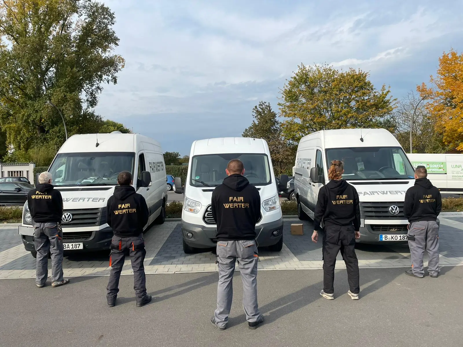 Foto von FAIRwerter Mitarbeitern vor Transportern