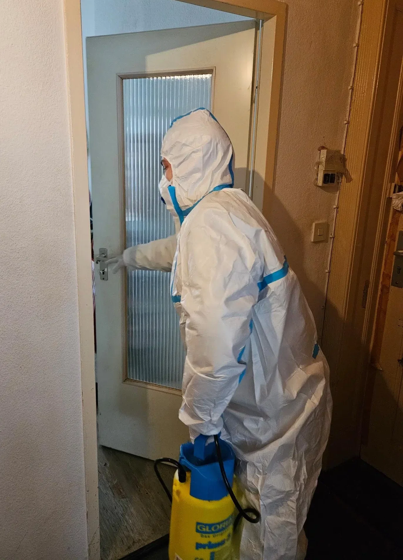 Tatortreinigung - FAIRwerter Mitarbeiter in Schutzanzug mit Maske