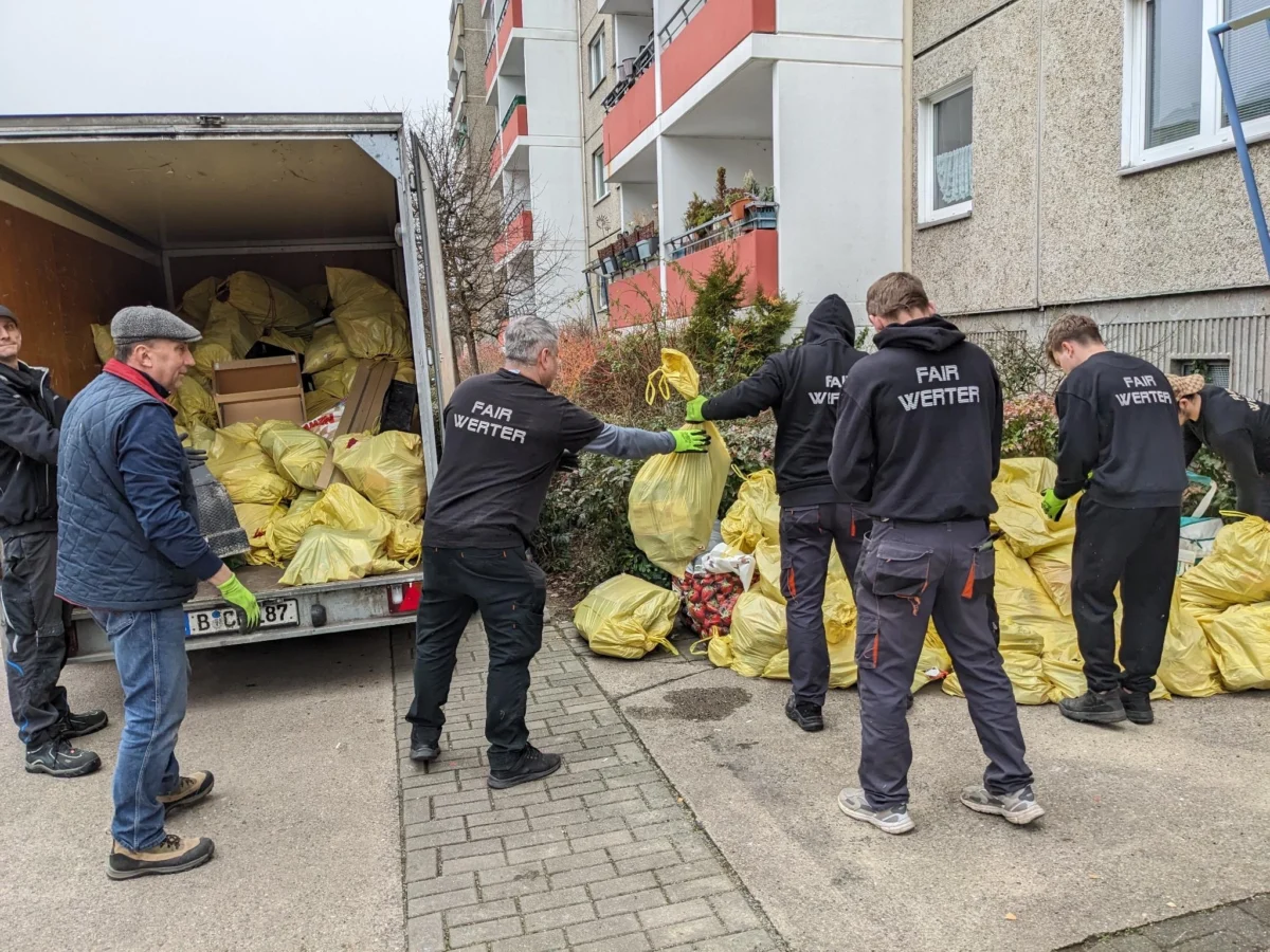 FAIRwerter_Säcketransport Mitarbeiter während einer Sperrmüllabholung beim Transporter beladen mit gepackten Säcken